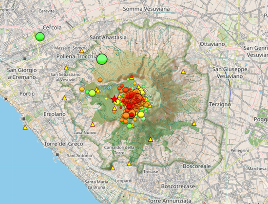 Map of Mount Vesuvius region from the GOSSIP website showing seismic activity. The map displays numerous colored dots concentrated mainly on the volcano, with red and orange circles indicating more recent events clustered around the crater area. Green circles represent older seismic events, while yellow triangles mark monitoring stations surrounding the volcano. The larger the circles, the stronger the seismic activity.