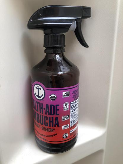 A brown glass bottle with a bright purple and red label and an anchor logo. The quality black spray nozzle fits perfectly. I moved my vinegar mix to it from a plastic bottle with an inferior nozzle that was leaking. This is what I use to keep my toilet diverter clean!