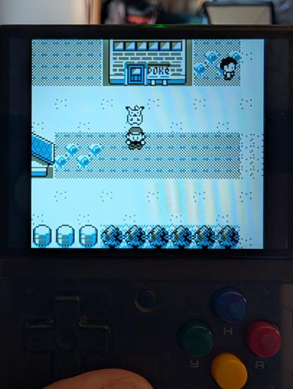 Low rez Gameboy screen image of me and Pikachu standing on the sidewalk in Pewter City.
