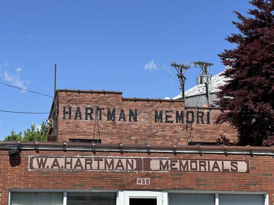 Two brick buildings, each with a different design of the text “Hartman memorials”.