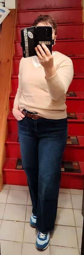 White T, wide leg jeans, champagne colored cashmere sweater, mocha belt, blue Adidas knock-offs. Layered necklaces, old lady clip earrings.