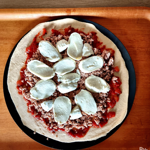 vue du dessus, une pizza sauce tomate thon et mozzarella pas cuite