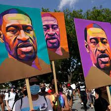 Protesters carrying signs with portraits of George Floyd.