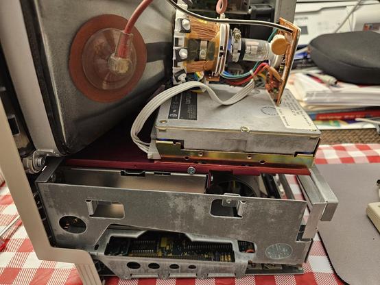 Inside view of a Macintosh SE showing a third party hard drive kit installed with a custom red bracket.