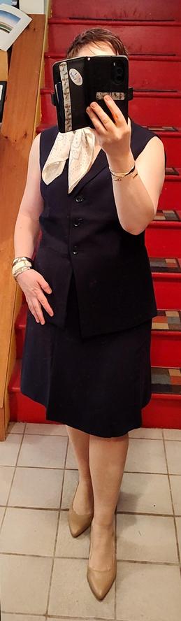 Navy A-line skirt, navy vest, beige slingbacks, bangle bracelets, neckerchief. Looks like a stewardess 😆😆😆