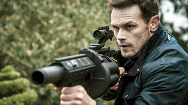 A man looking really tough holding a grenade launcher.