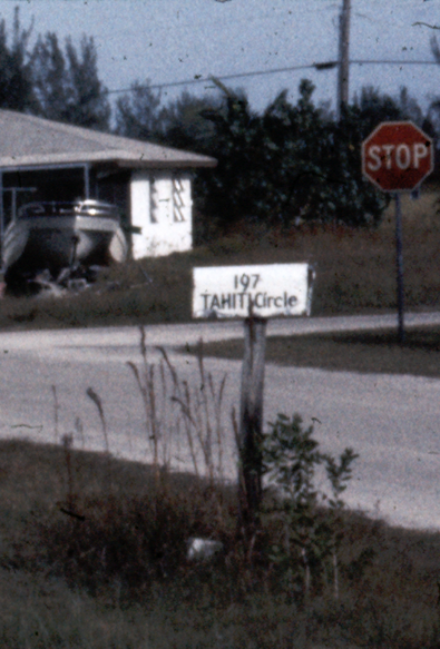 A cropped piece of a 1976 35 mm slide that has an address painted on a mailbox.