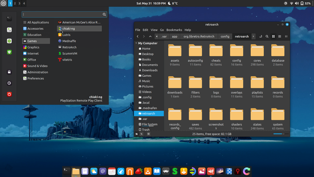 My LMDE desktop. I have my menu open to the Games category showing American McGee's Alice, chiaki-ng, Lutris, Mednaffe, RetroArch, ScummVM, and vitetris. On the right the file manager is open showing my Retroarch folder (didn't want to show anything personal)! On the bottom is a dock where one can see icons for all my most-used programs. On the top is a system bar showing the time, date, battery life, volume icon, wifi, desktop switcher, and menu.