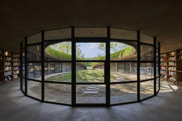 Interior view looking out into a circular green courtyard.