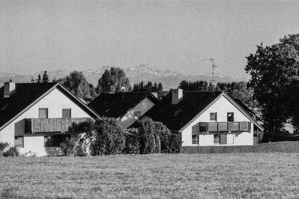 Siedlungshäuser mit Bergen im Hintergrund