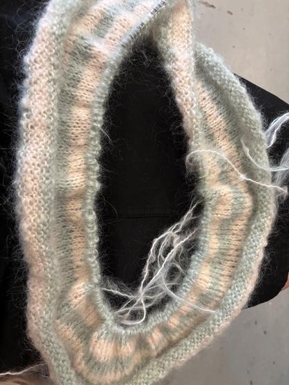 A sideways photo of my lap with my knitting project on it. It’s the very beginning of a dress designed by embraknit. It is a striped tube basically. My stripes are peach and mint, very pastel.