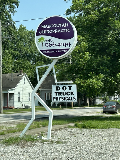 A chiropractor sign that is a metal stick figure bent over like someone with back pain