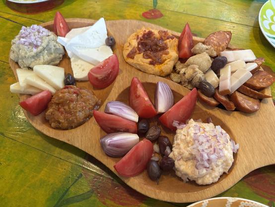 Selection of food, cheeses and sausage on a board.
