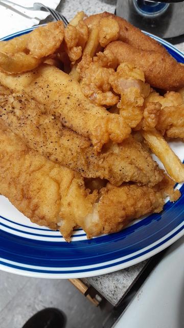 I plate with strips of fish, popcorn shrimp, hush puppies and french fries