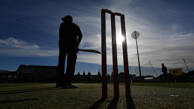 Les derniers rayons du soleil éclaire un joueur de cricket au bâton.
