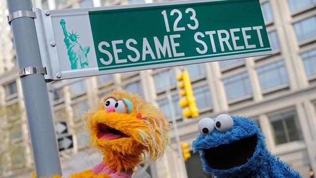 Sesame Street puppet charactors Zoe (L) and Cookie Monster (R) pose next to temporarty street sign November 9, 2009 at West 64th Street and Broadway in New York on the eve of the 40th anniversary of the broadcast of the children's television show. The sign is located across the street from Sesame Workshop's corporate headquarters which will launch the 40th season of Sesame Street on PBS on November 10. AFP PHOTO/Stan Honda (Photo credit should read STAN HONDA/AFP via Getty Images)