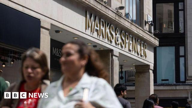 A Marks & Spencer shop on a busy high street in summer