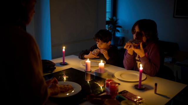 A family eats a snack by candlelight during a blackout in Barcelona, Spain, 28 April 2025. | Copyright AP Photo/Emilio Morenatti