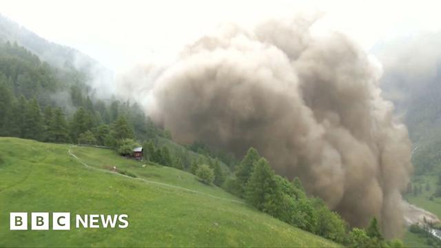 A cloud of dust from an avalance of the Birch Glacier swells over the Swiss village of Blatten