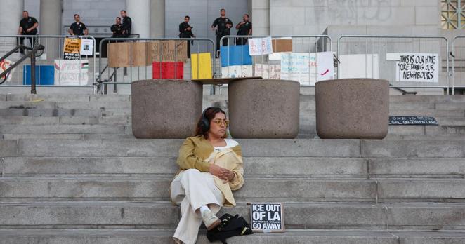 Los Angeles, CA - June 15: A protestor sits on the steps of City Hall after an anti-ICE demonstration at Los Angeles City Hall on Sunday, June 15, 2025 in Los Angeles, CA. (Jason Armond / Los Angeles Times)