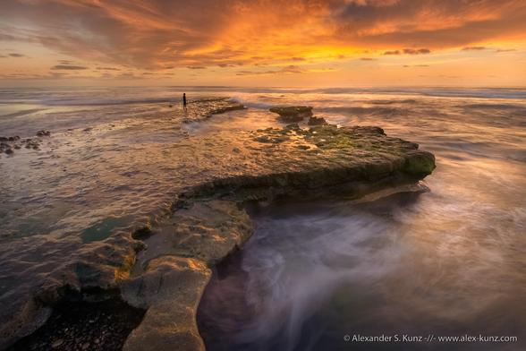 A boy enjoys the first sunset of 2020 at the tide pools of Tabletop Reef, Solana Beach, California. January 2020.