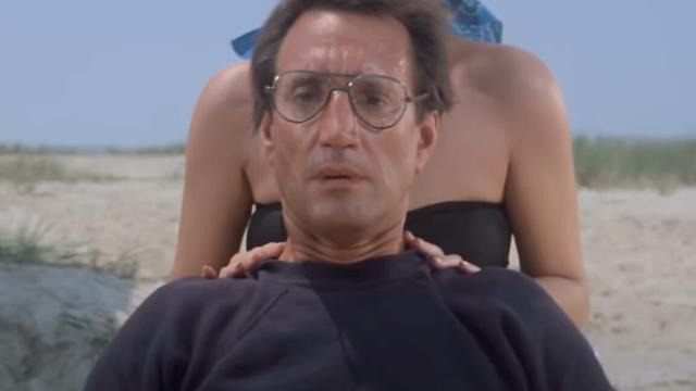closeup of man in glasses on the beach looking out to the water with growing horror