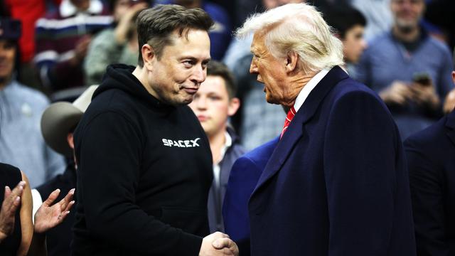 Elon Musk shakes hands with Donald Trump.