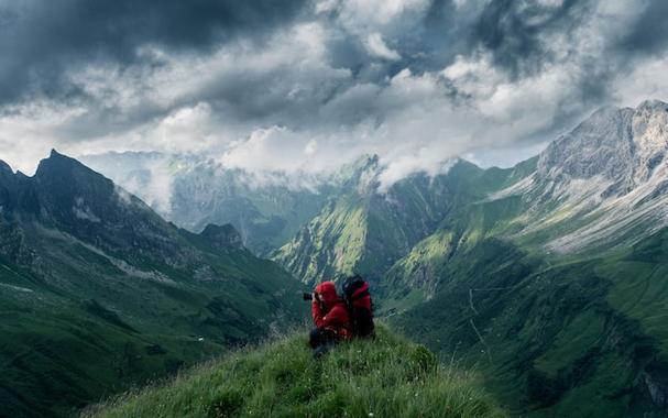 Woman sitting on a mountain under a cloudy sky imported using WordPress External Images Plugin