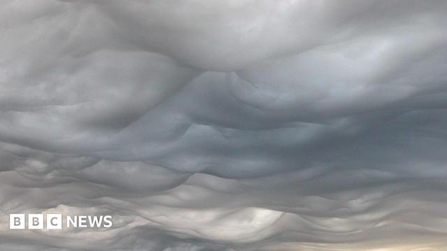 Image of a wide sky with heavy, undulating cloud over a landscape