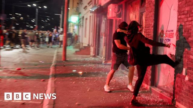 Anti-government protesters break the windows of the offices of the ruling Serbian Progressive Party