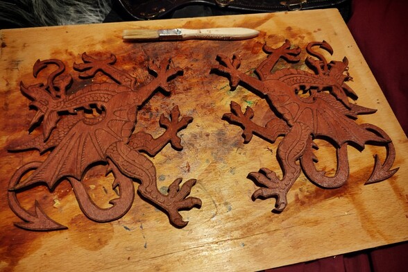 deux faces du dragon pour faire l'enseigne de pub, découpées au laser (basées sur le dragon gallois) et posées côte à côte sur une planche à sécher après teinture en merisier. 