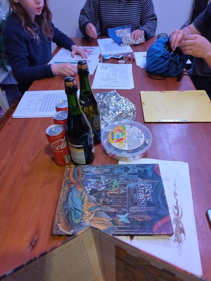 Un table avec des bouteilles des bonbons et les règles cartonné de la v2 de rêve de dragon