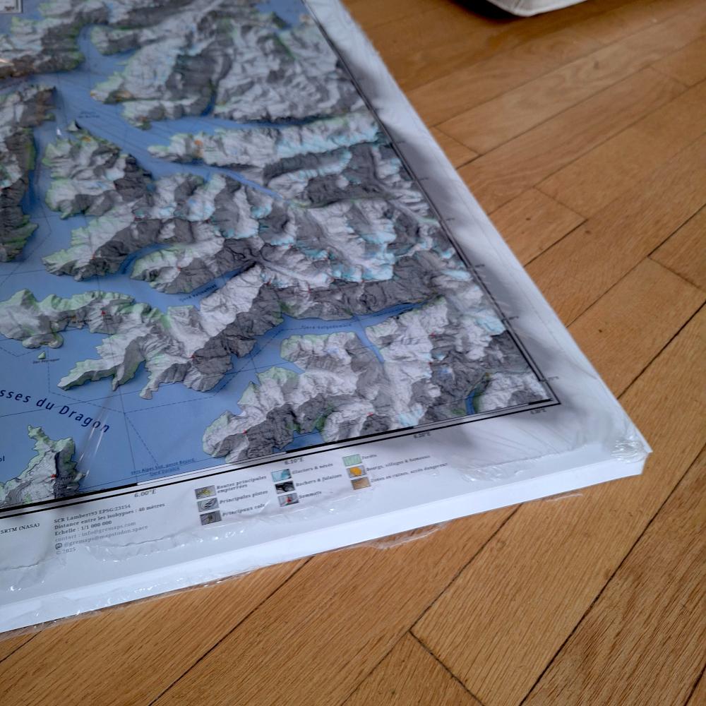Affiches d'une carte géographique de l'ouest du massif de l'OIsans, avec un niveau de la mer à 1400 mètres au-dessus du niveau réel. L'image montre un paquet d'affiches posé au sol.