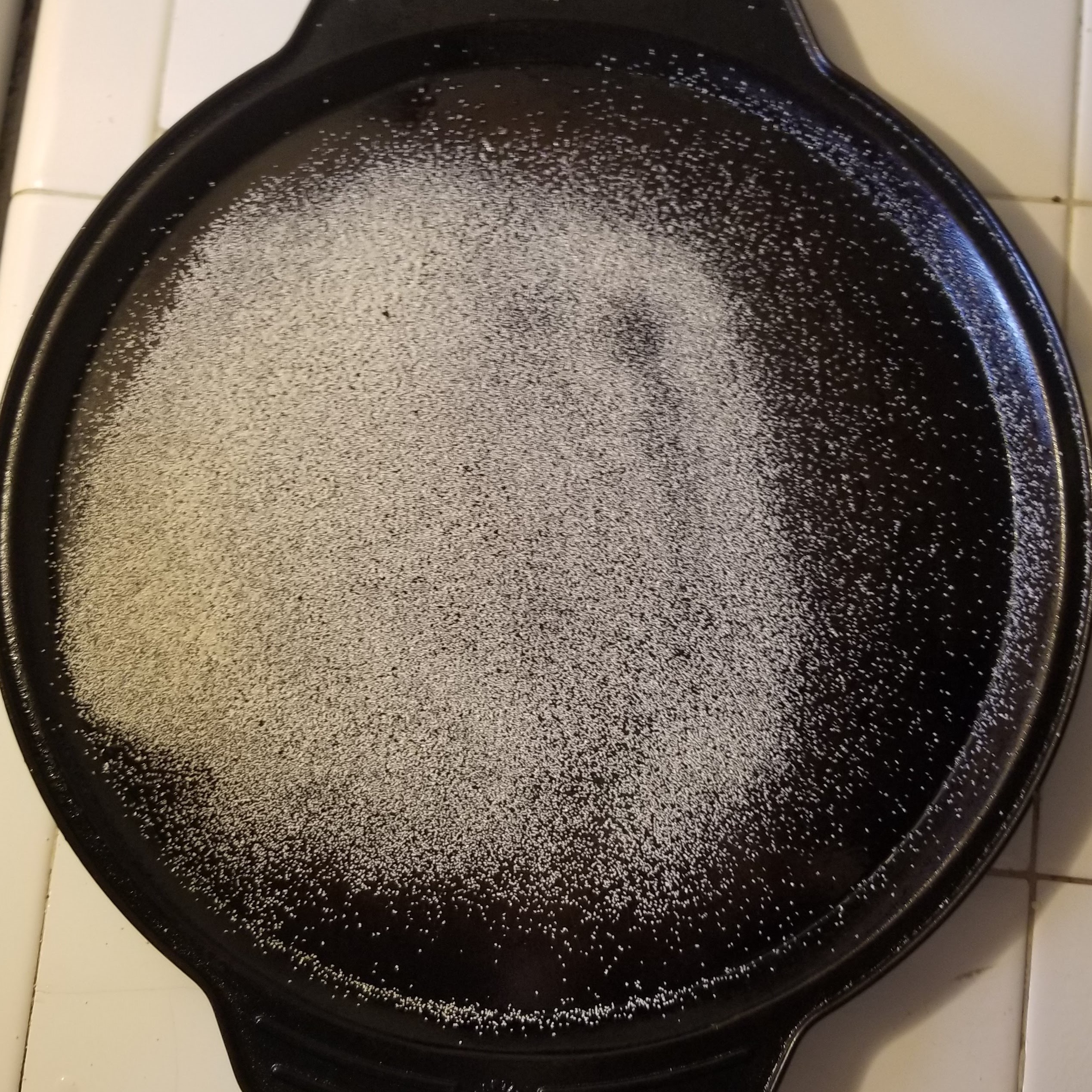 A round baking pan with semolina flour dusted across it.
