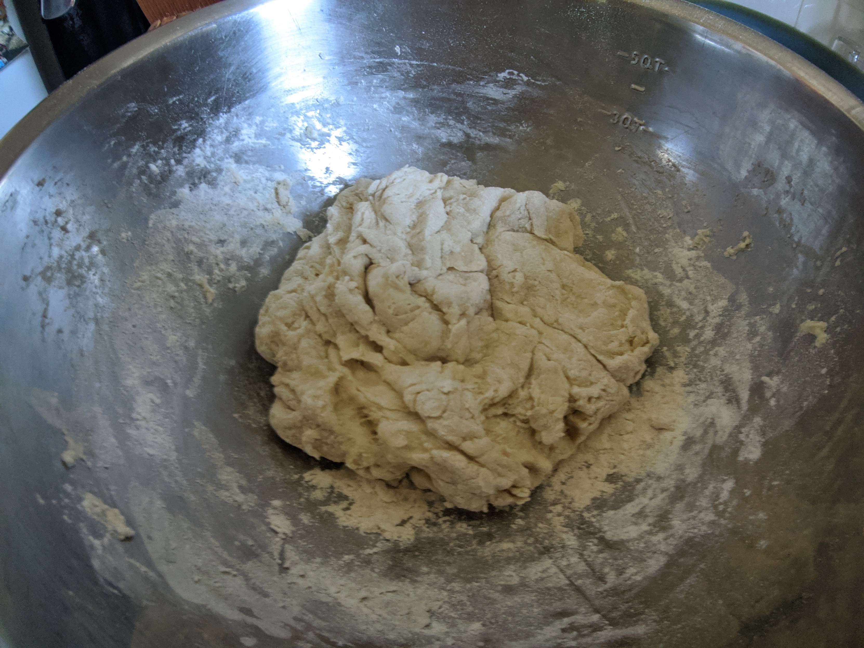 Mixing bowl full of dough that is no longer sticky to touch.