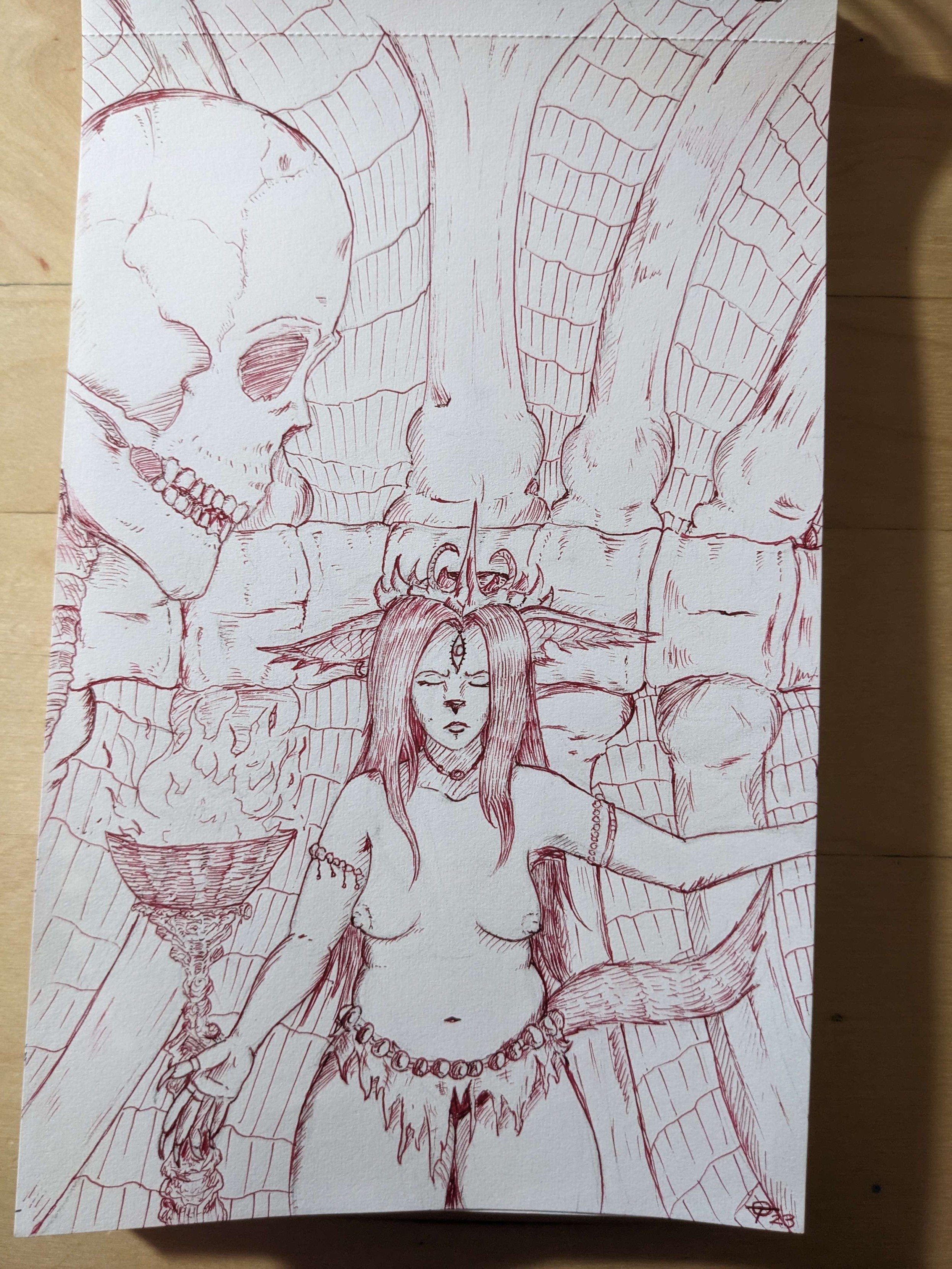 A drawing in red ink of a woman with fox like features. She is standing in a skeletal looking chamber with a burning brazier next to her and a massive skull behind her. She wears a tattered cloth on her waist and no other clothing. On her head is a pointy crown and she has an eye like tattoo on her forehead.