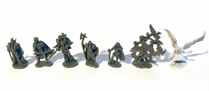 Seven unpainted D&D miniatures. From left to right: Four undead knights, a female warrior / knight, a hovering, female vampire, surrounded by bats, and a wereraven.