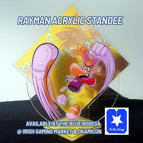 Photo of the Rayman Acrylic Standee. Text reads: Rayman Acrylic Standee. Available at The Blue Bodega @ Irish Gaming Market & Okamicon.