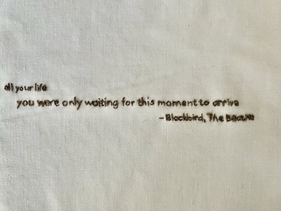 Another partially illegible quote embroidered in brown wool:

all your life
you were only waiting for this moment to [sic] arrive

– The Beatles
