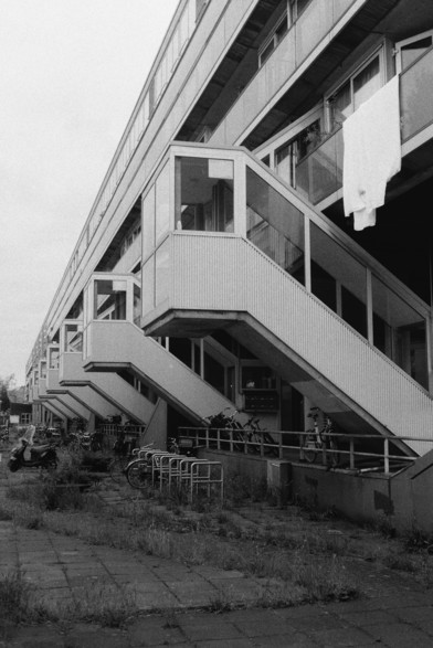 Black and white photograph of stairwells on the side of a housing complex.