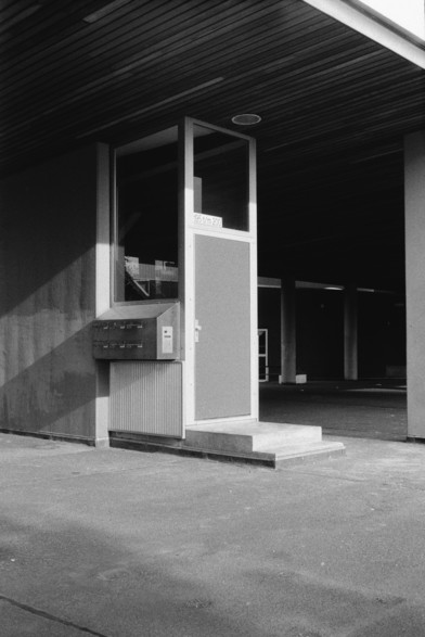Black and white photograph of an entrance leading up a housing complex.