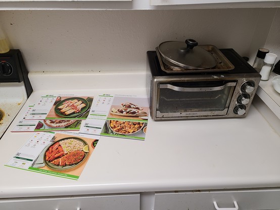 Photo of a kitchen counter with a toaster oven and Hello Fresh recipe cards on it. There is plenty of space! 