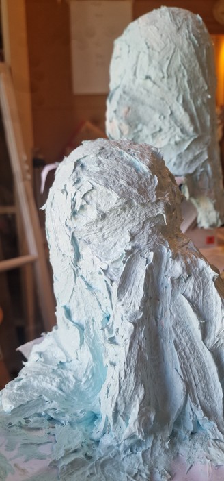 Two blue-white molds in wet mold mix slurry. 