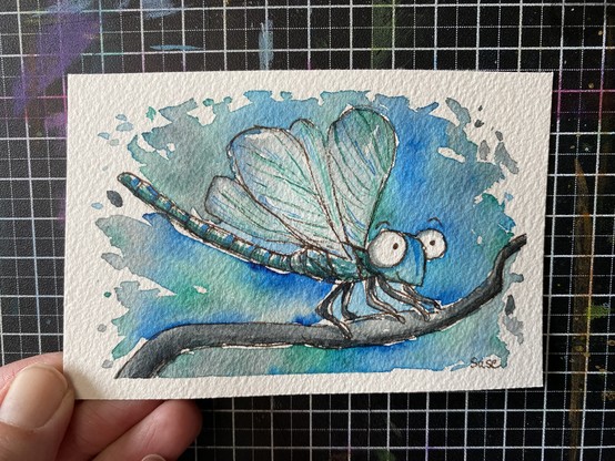 Eine cartoon Libelle nur mit 3 Farben gezeichnet und großen Augen. Blau, Grün, Schwarz.
