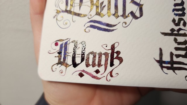 Closer shot of the word 'Wank' showing the sheen and shimmer in the still-wet ink. It's very sparkly.