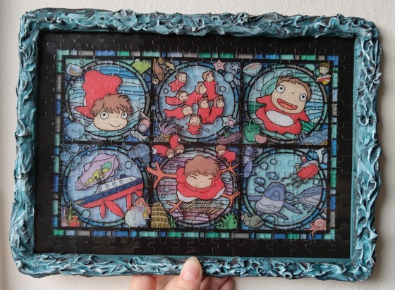 A stained glass Ghibli puzzle of Ponyo in a frame that looks like a very active sea.