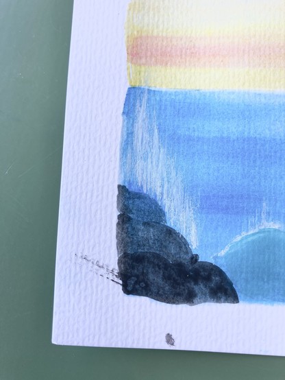 Bottom left corner of my gouache painting. In the background the blue sea and red-Orange sky. Focus, though is on two splatters of black paint on the border that was supposed to stay white