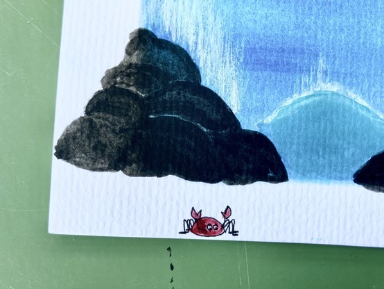 Bottom left corner of my gouache painting. In the background the blue sea and some waves. The splatters (see previous image) were fixed by expanding some black rocks into the white border to cover the first splatter. The second one was turned into a crab. 