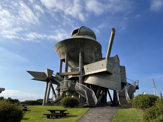 A telescope observatory that looks like a spaceship crashed into the ground and exploded. It’s made of concrete.