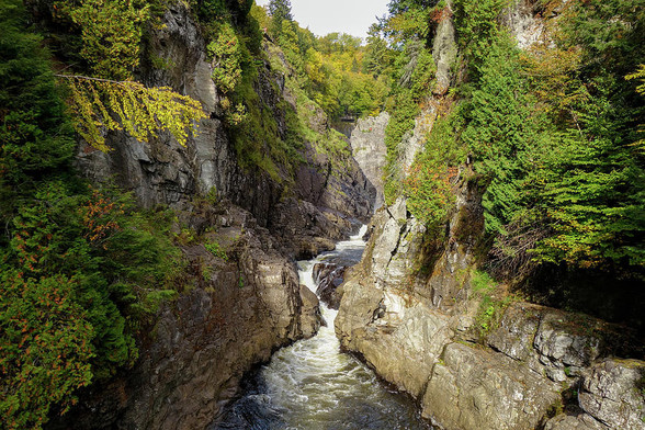 A view of a river flowing through the cliffs of Saint Anne's Canyon near Quebec City on a bright and sunny Autumn day. 